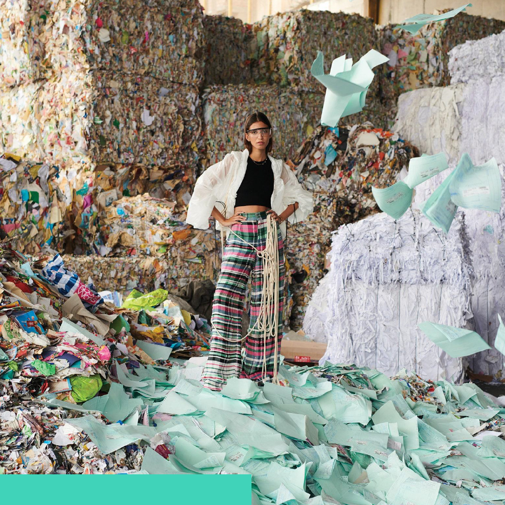 Chica posando en pila de reciclaje